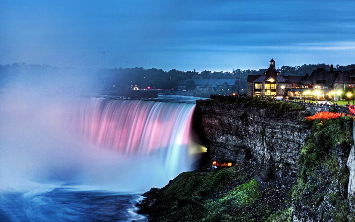 Niagara Falls illuminated at night.