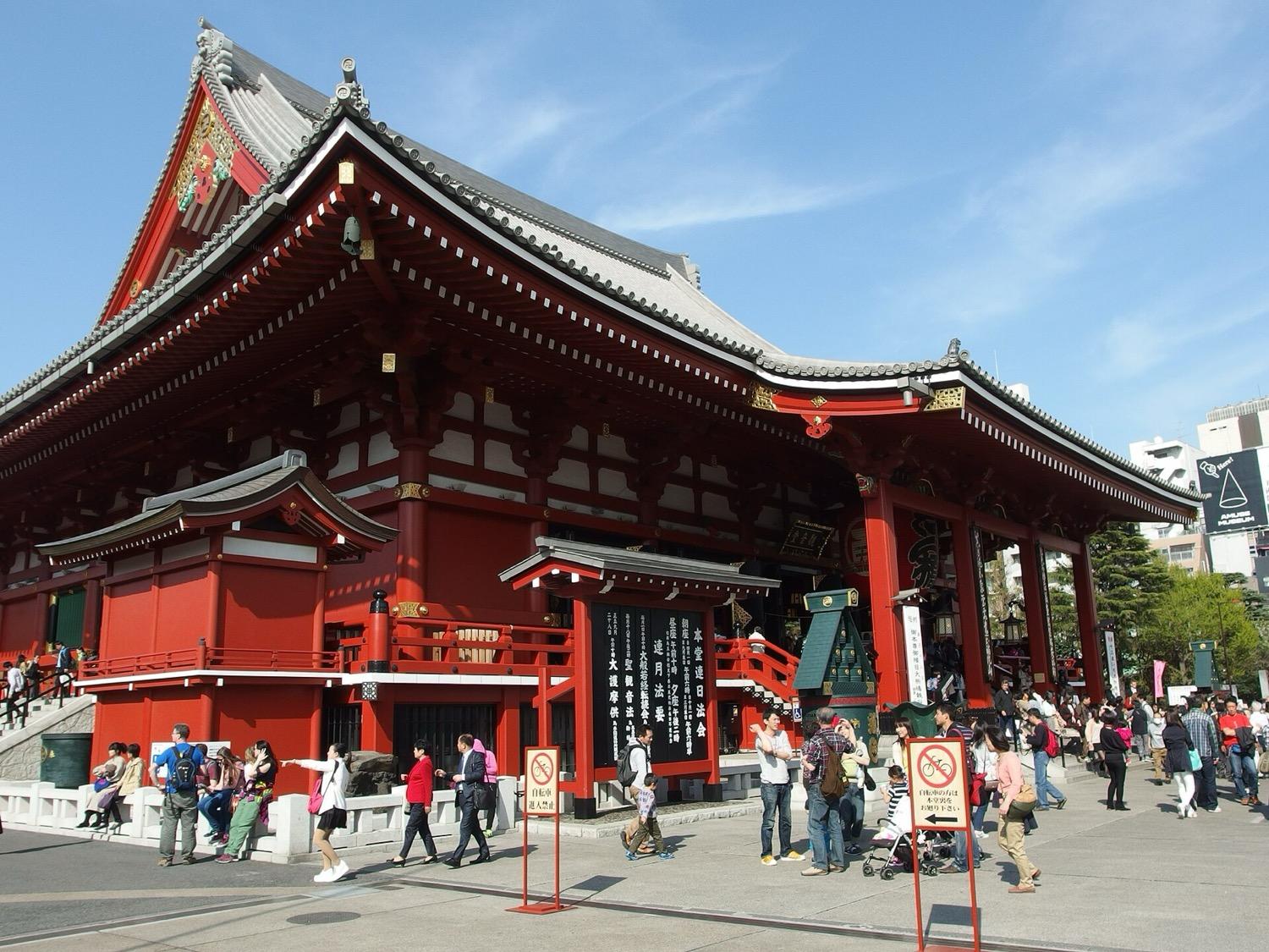 The red main hall of Senso-ji temple in Asakusa under a blue sky