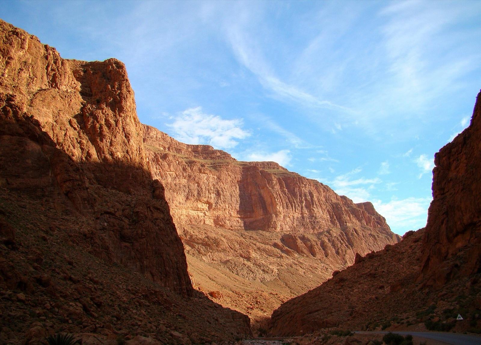 The red rock walls of the Todra Gorge in morning sun under a blue sky