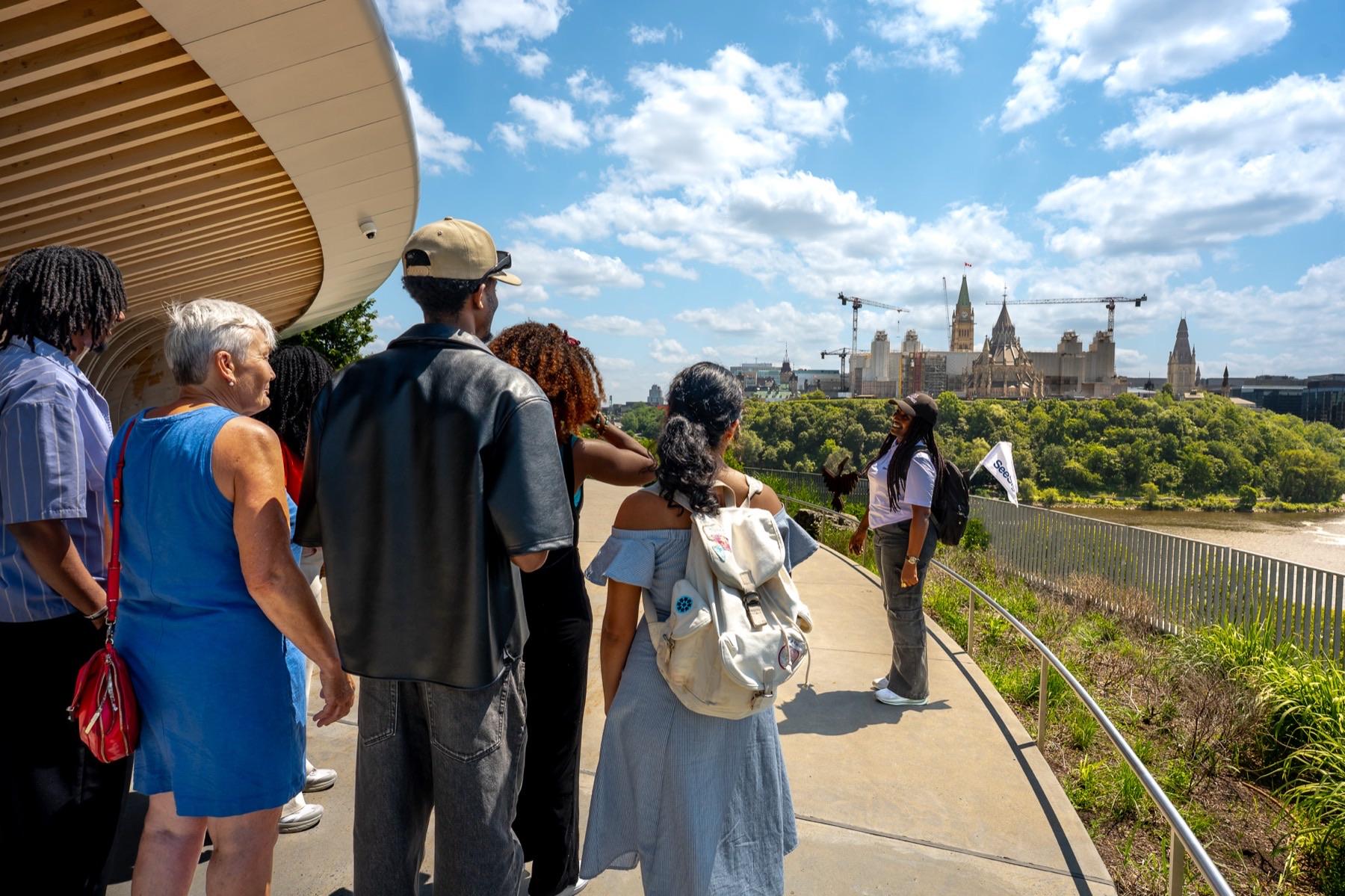 Guests at a lookout above the Ottawa River with Parliament Hill in the distance