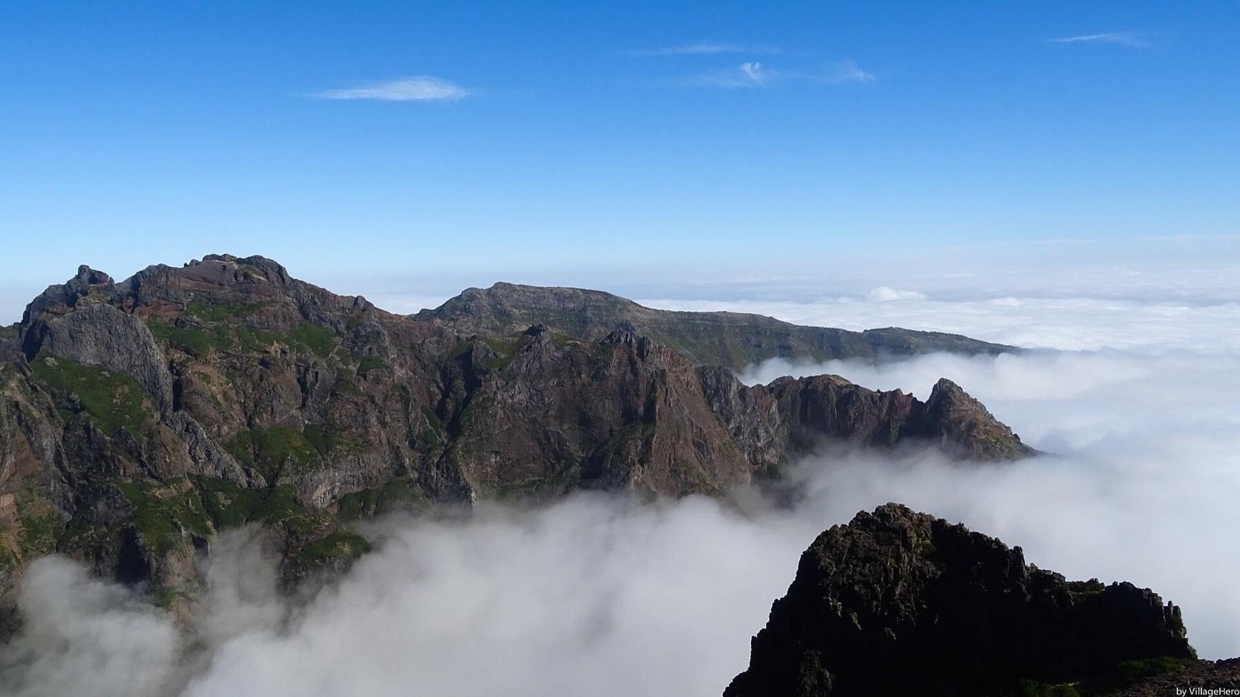 Jagged volcanic peaks rise out of low cloud on the ridge between Pico do Arieiro and Pico Ruivo
