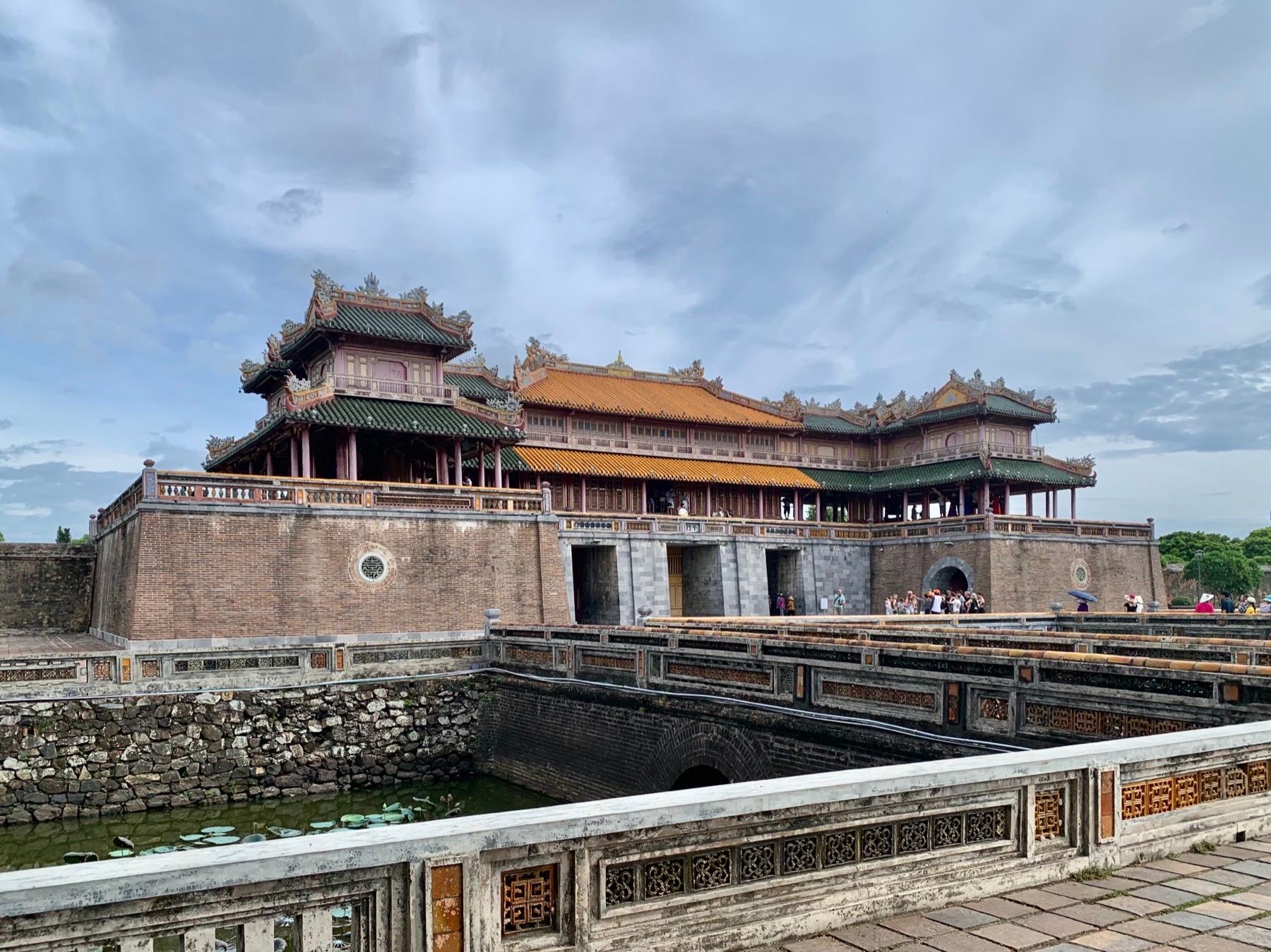 The Meridian Gate of the Imperial City in Hue, with its tiled two-tier pavilion above a brick wall and moat
