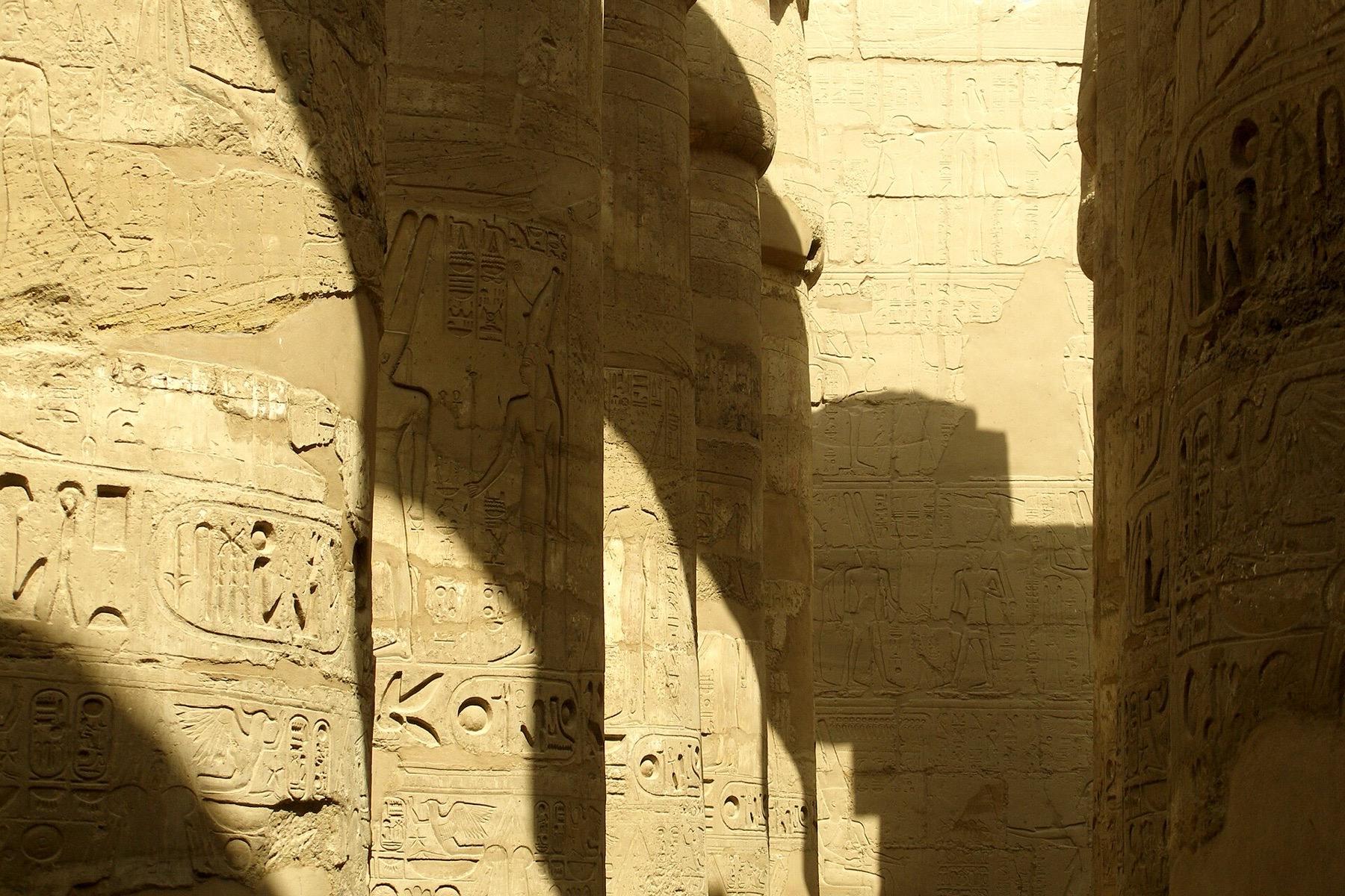 Low sun and deep shadow across the carved columns of the Great Hypostyle Hall at Karnak