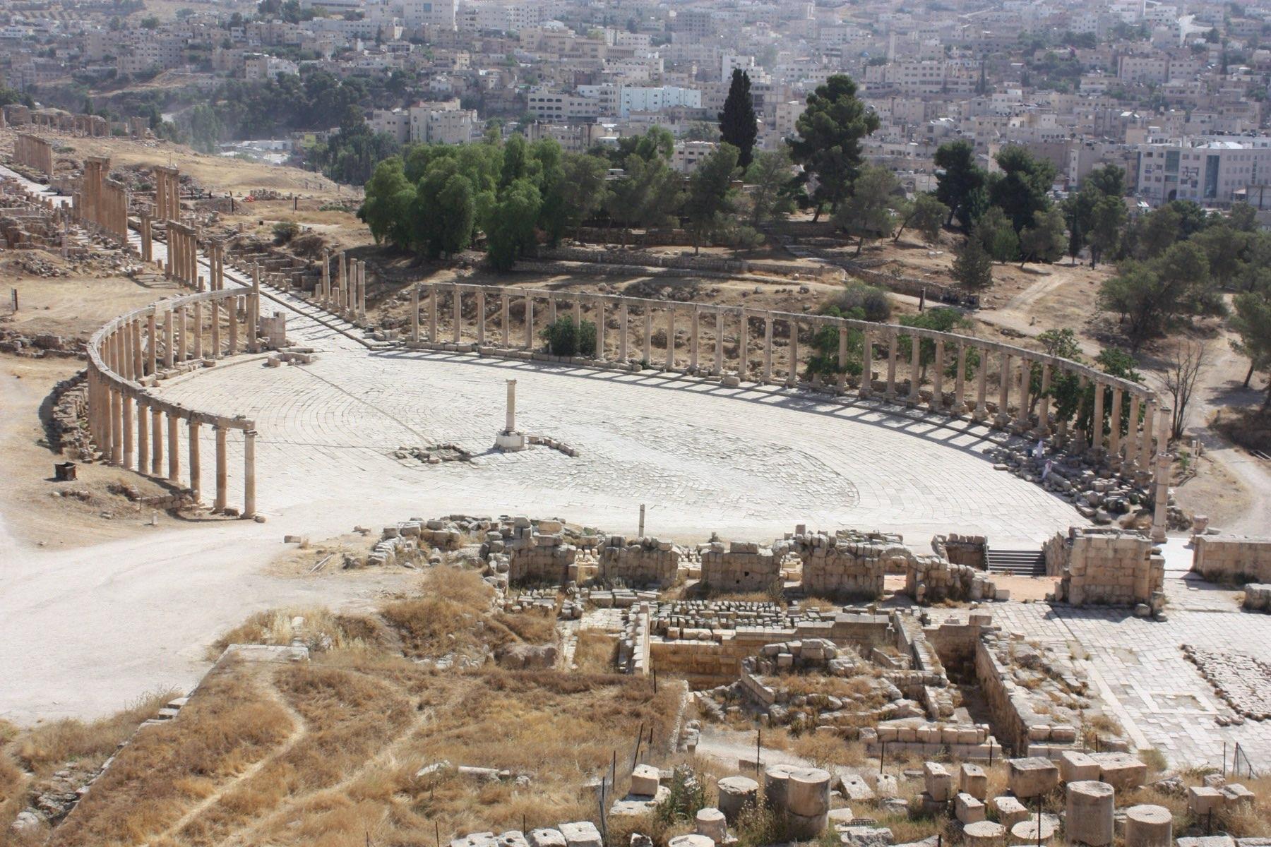 The colonnaded Oval Plaza of Roman Jerash seen from above, with the modern town beyond