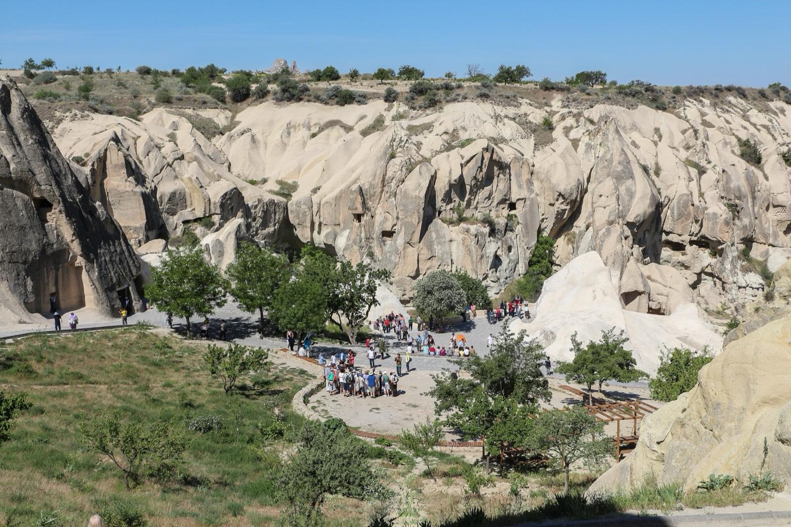 Rock cones carved with chapels and cells at the Göreme Open Air Museum, under a blue sky