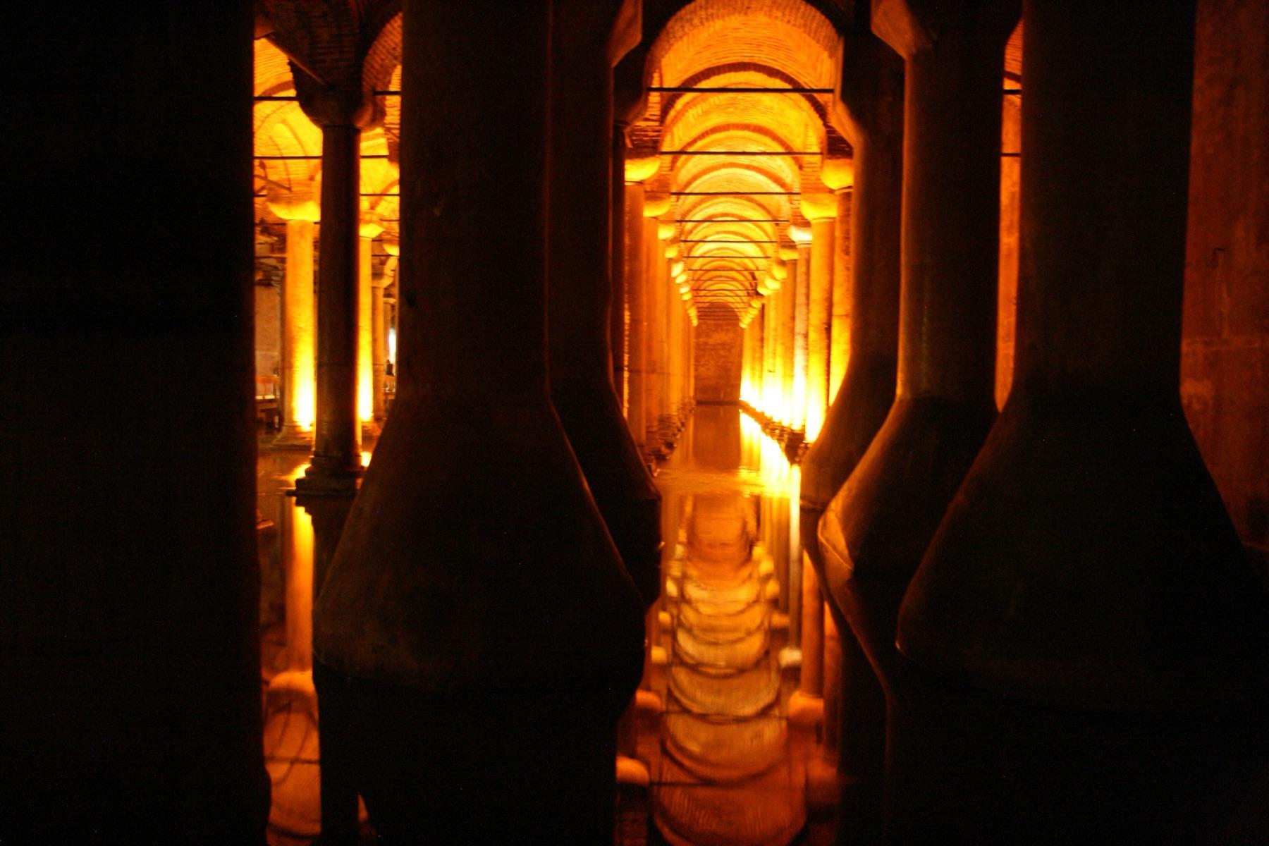 Rows of lit stone columns reflected in the water of the Basilica Cistern