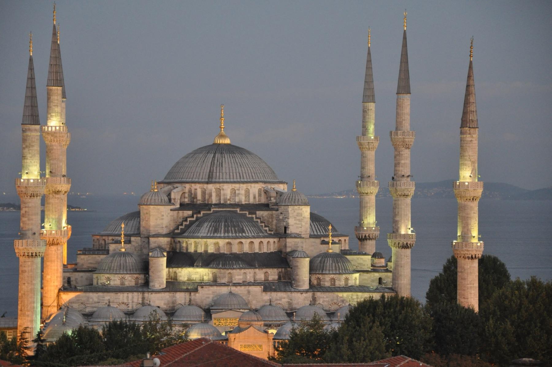 The domes and six minarets of the Blue Mosque lit up at dusk above Sultanahmet rooftops