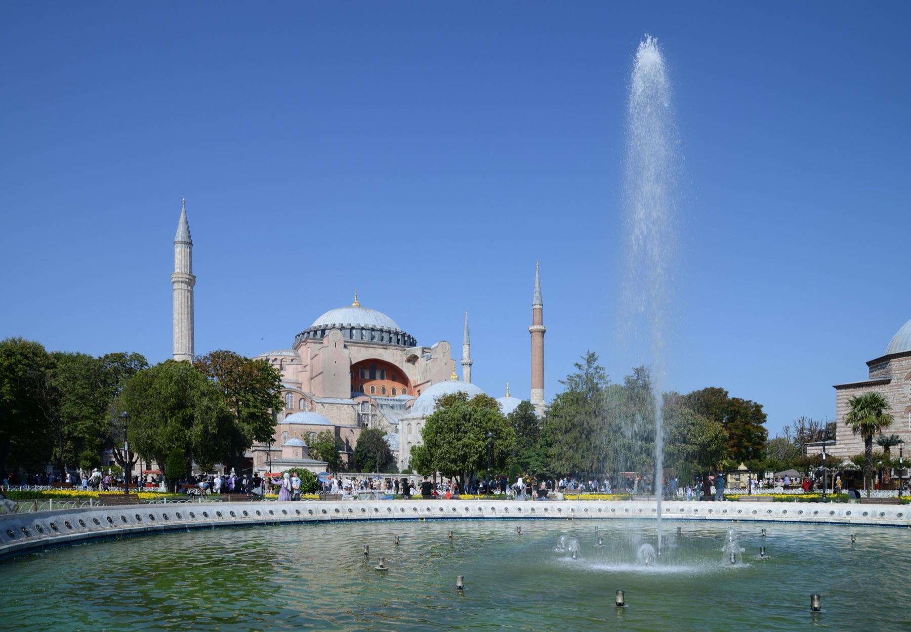 Hagia Sophia and its minarets seen across the fountain in Sultanahmet Park on a clear summer day