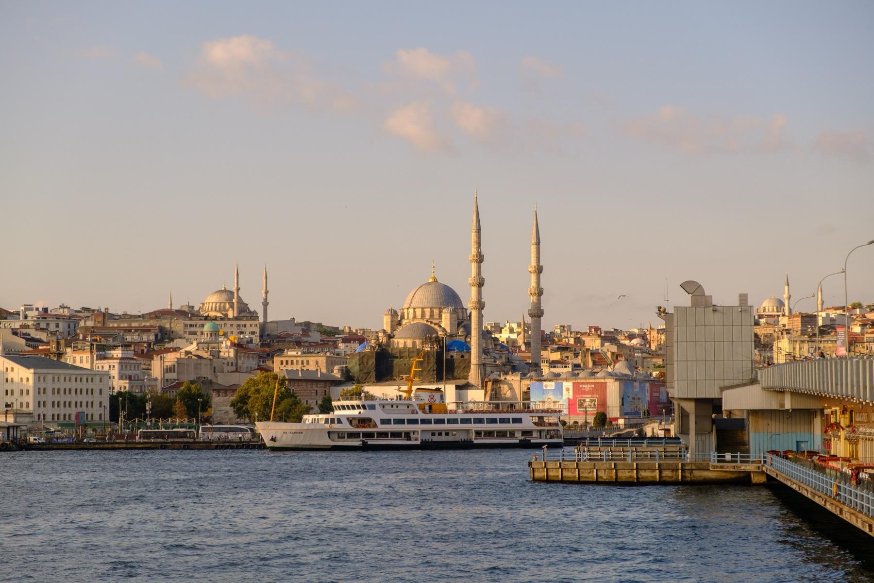 The Eminönü waterfront with the New Mosque and the Süleymaniye Mosque on the hill behind, seen from the Galata Bridge in late light