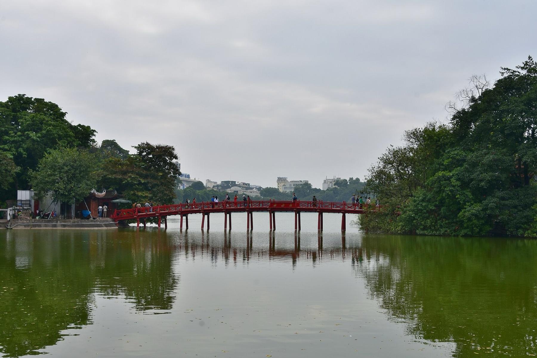 The red The Huc Bridge crossing Hoan Kiem Lake in Hanoi to the island of Ngoc Son Temple