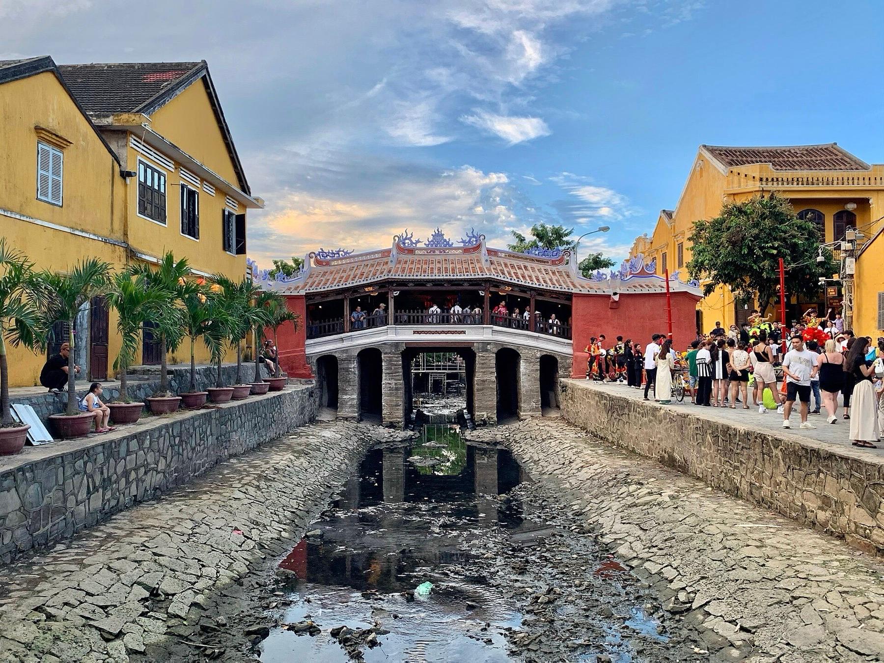 The Japanese Covered Bridge in Hoi An after its 2024 restoration, between yellow merchant houses