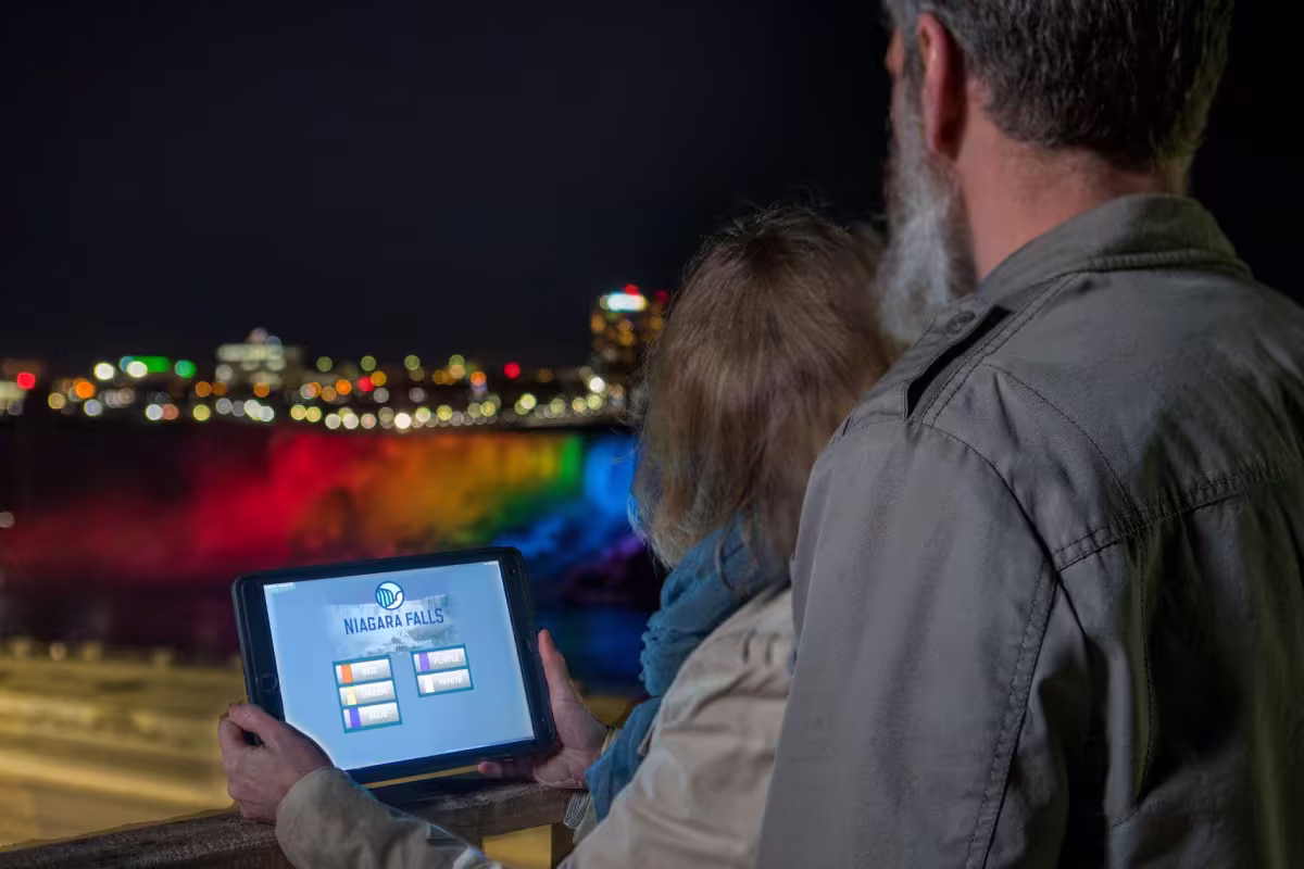 People using tablet to control Niagara Falls night lights.