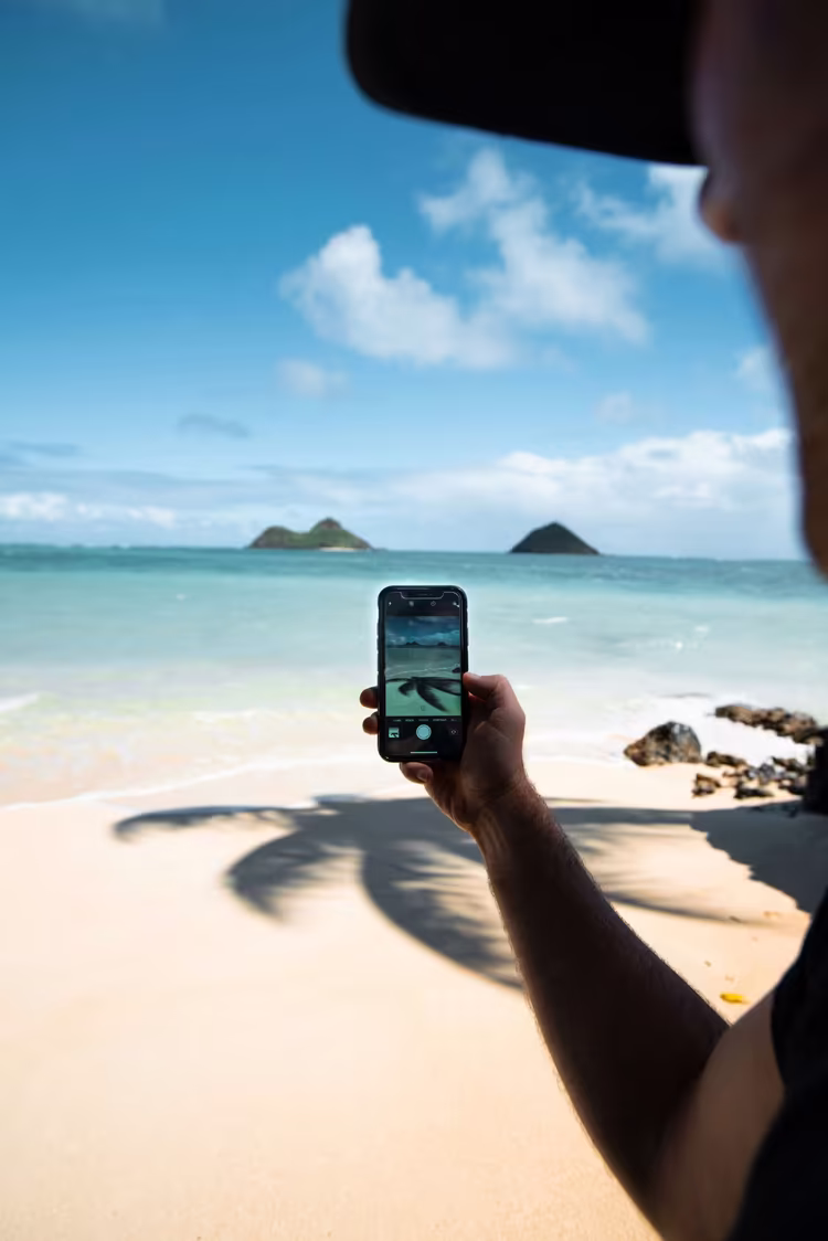 Person taking photo of tropical islands with phone