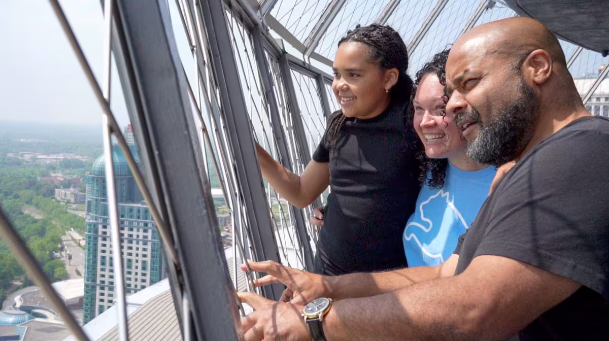 Family enjoying Niagara Falls views from Skylon Tower observation deck.