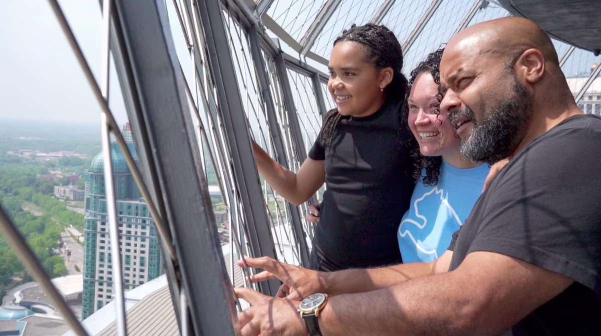 Family enjoying Niagara Falls views from Skylon Tower observation deck.