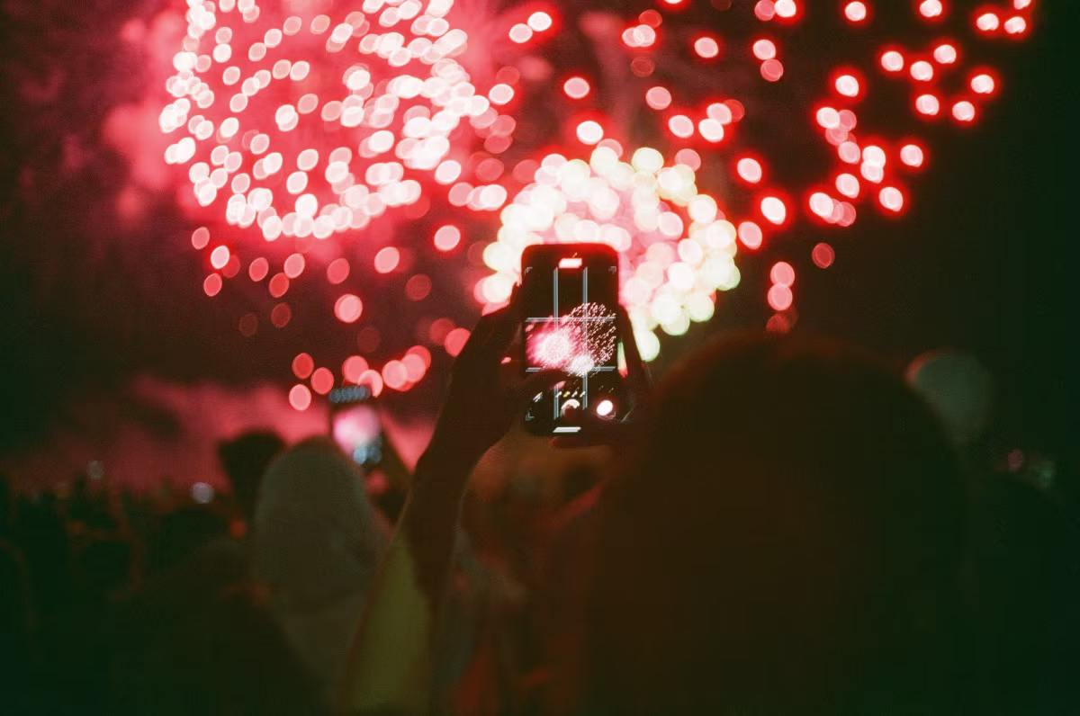 Visitors taking photos of fireworks over Niagara Falls.