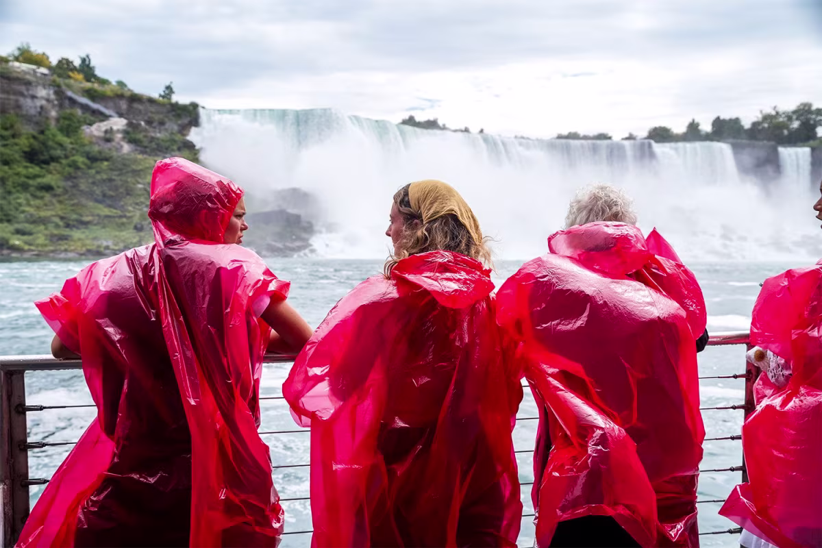 Friends enjoying themselves at Niagara Falls wearing red ponchos.