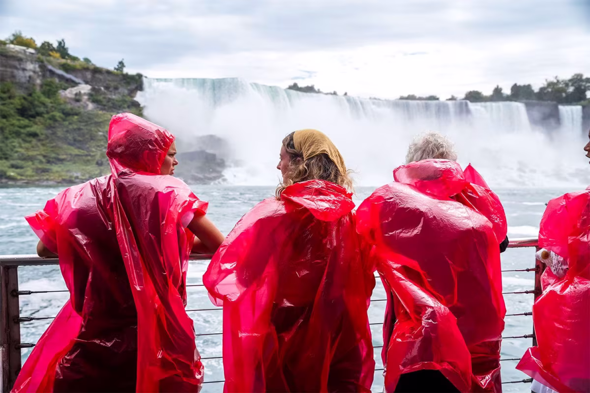 Friends enjoying themselves at Niagara Falls wearing red ponchos.