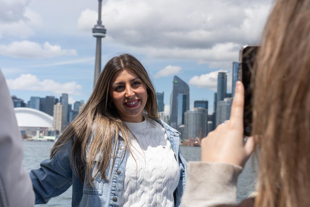 A guest at the Toronto harbourfront with the city skyline