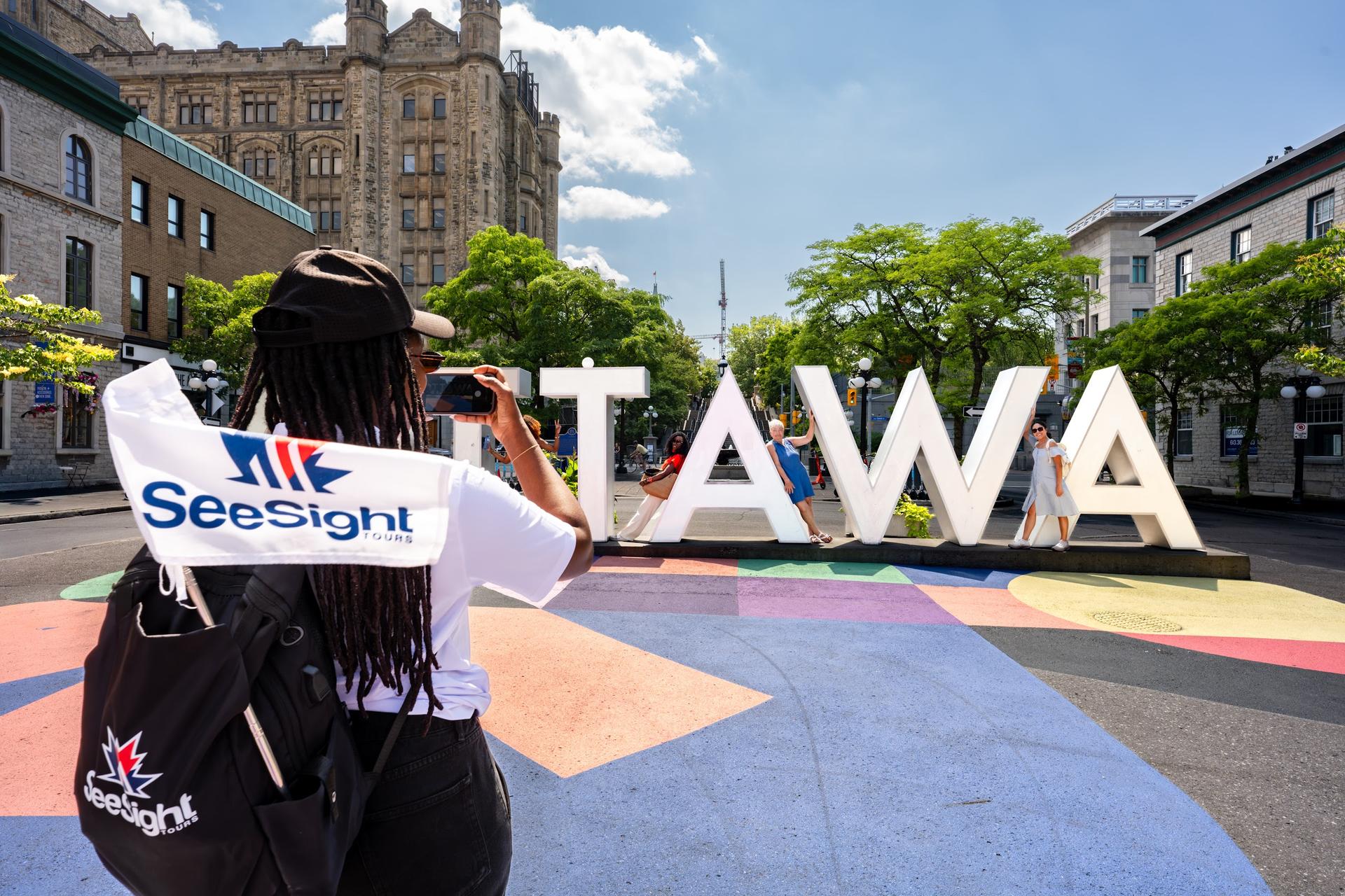 See Sight guide at the Ottawa sign with the tour flag