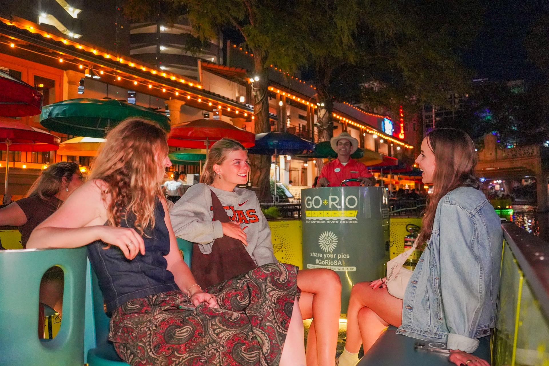 Guests on a River Walk boat in San Antonio at night