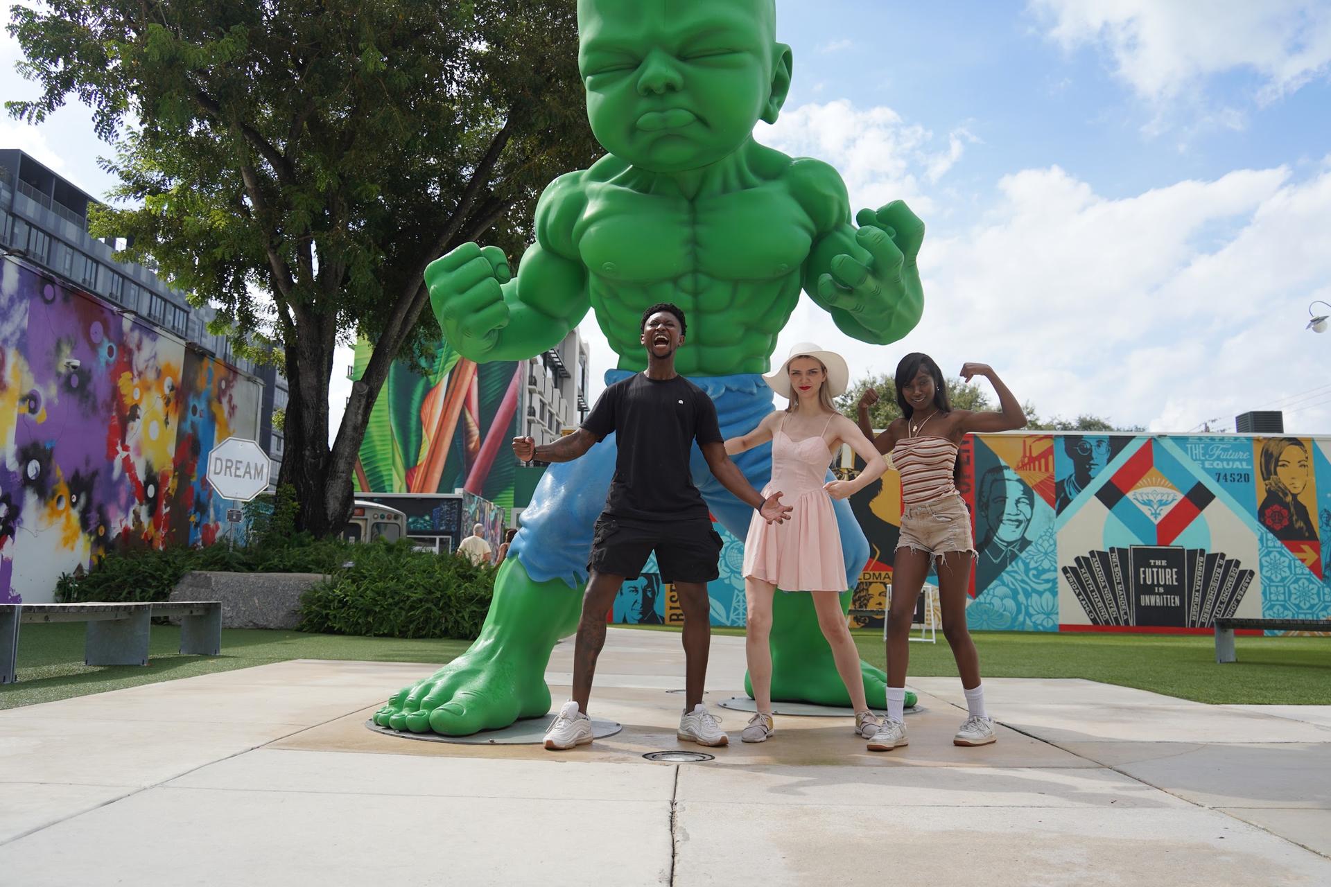 Guests pose by a giant sculpture in the Wynwood Walls area of Miami
