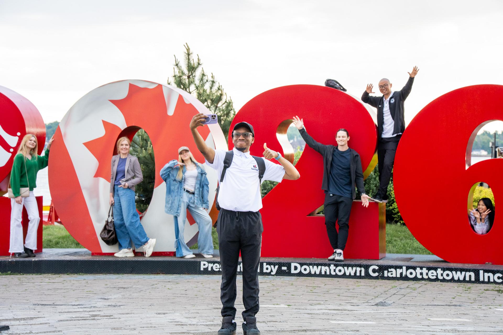 Guests cheer at the Charlottetown sign with their guide