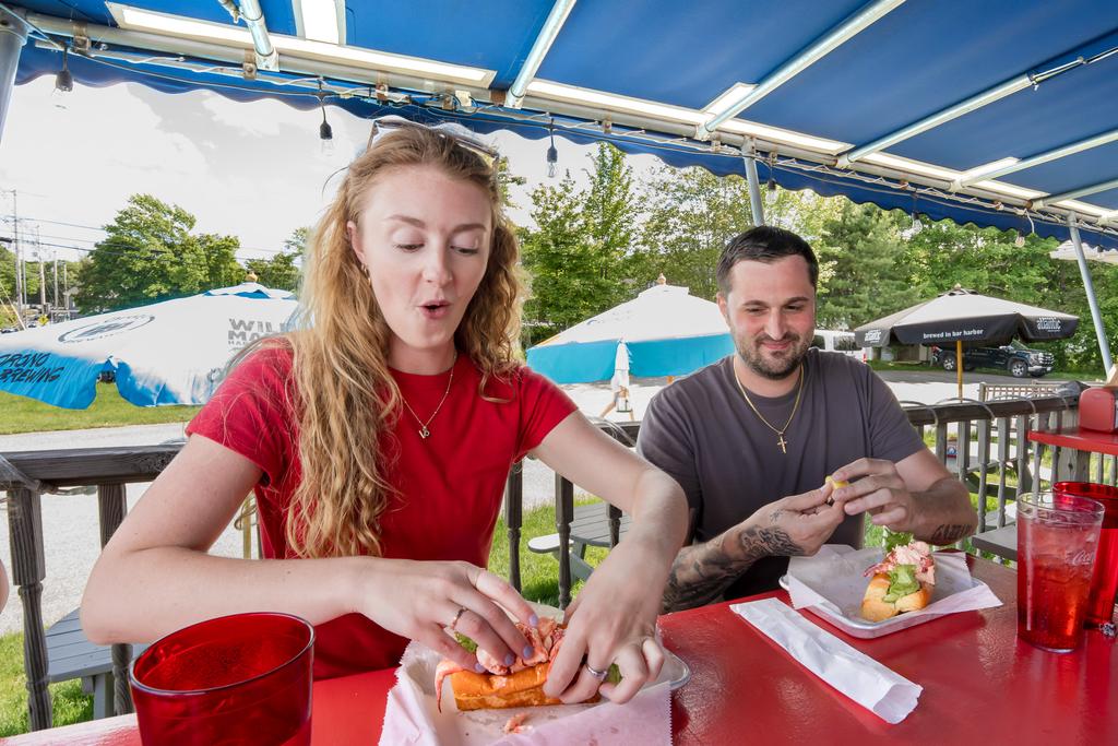 A guest eats a lobster roll in Bar Harbor