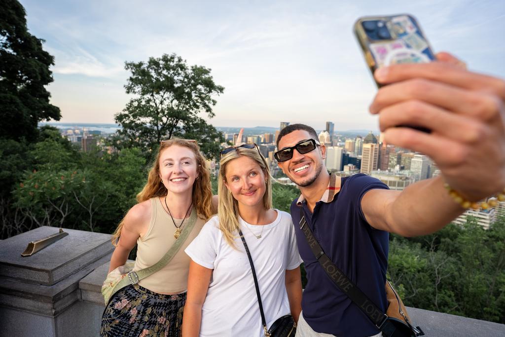 Guests take a selfie at the Mount Royal lookout over Montreal