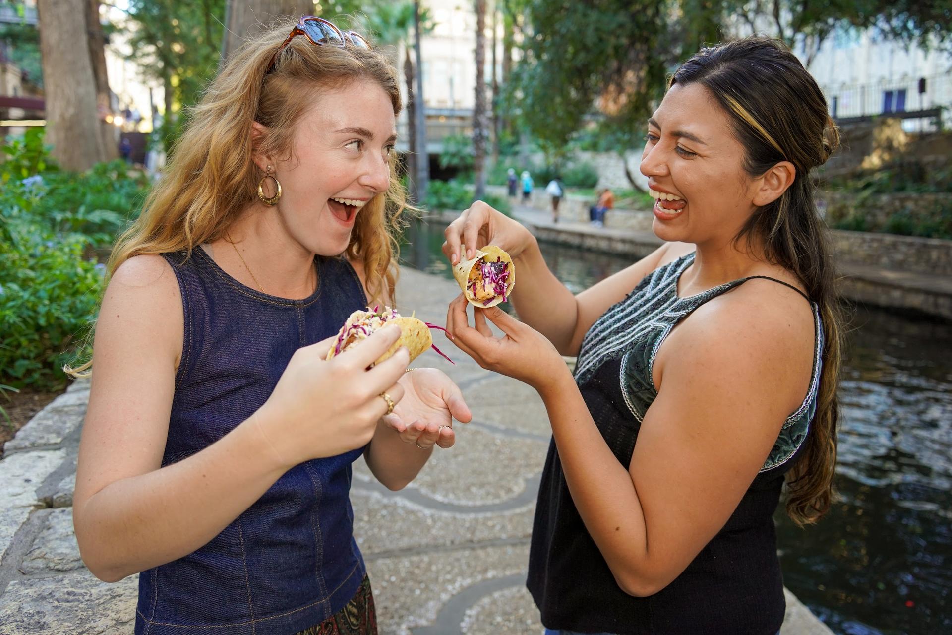 Guests taste tacos beside the San Antonio River Walk