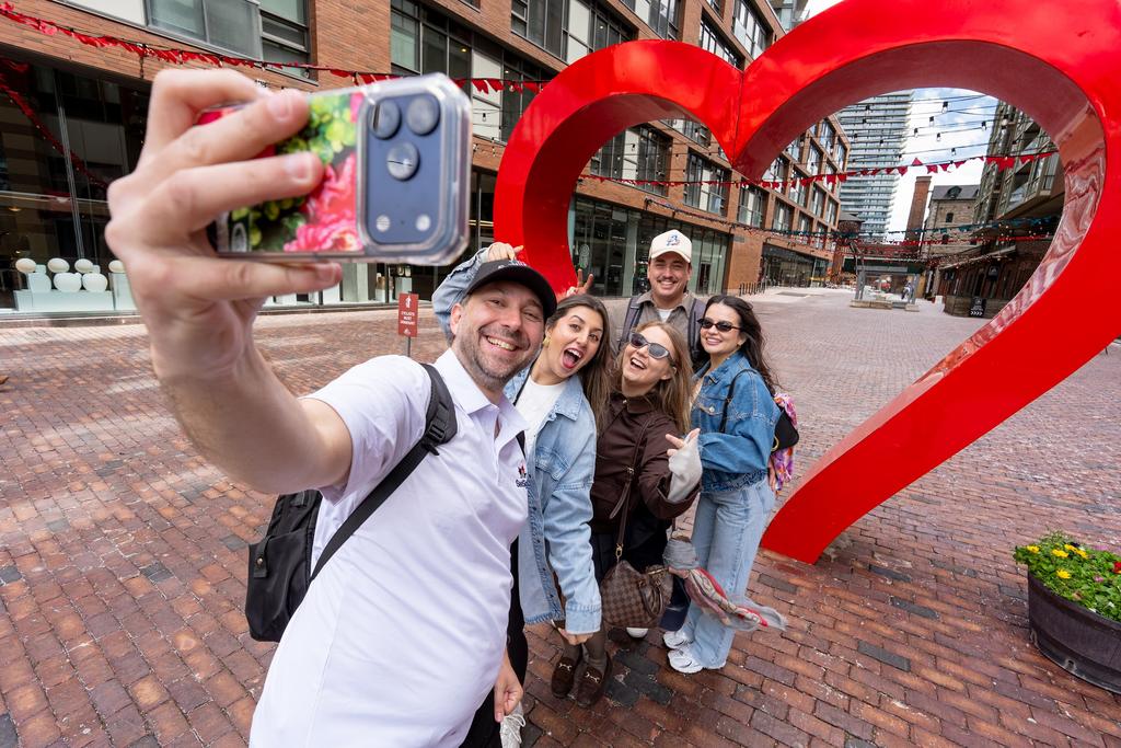 Guests take a selfie at the heart sculpture in the Distillery District