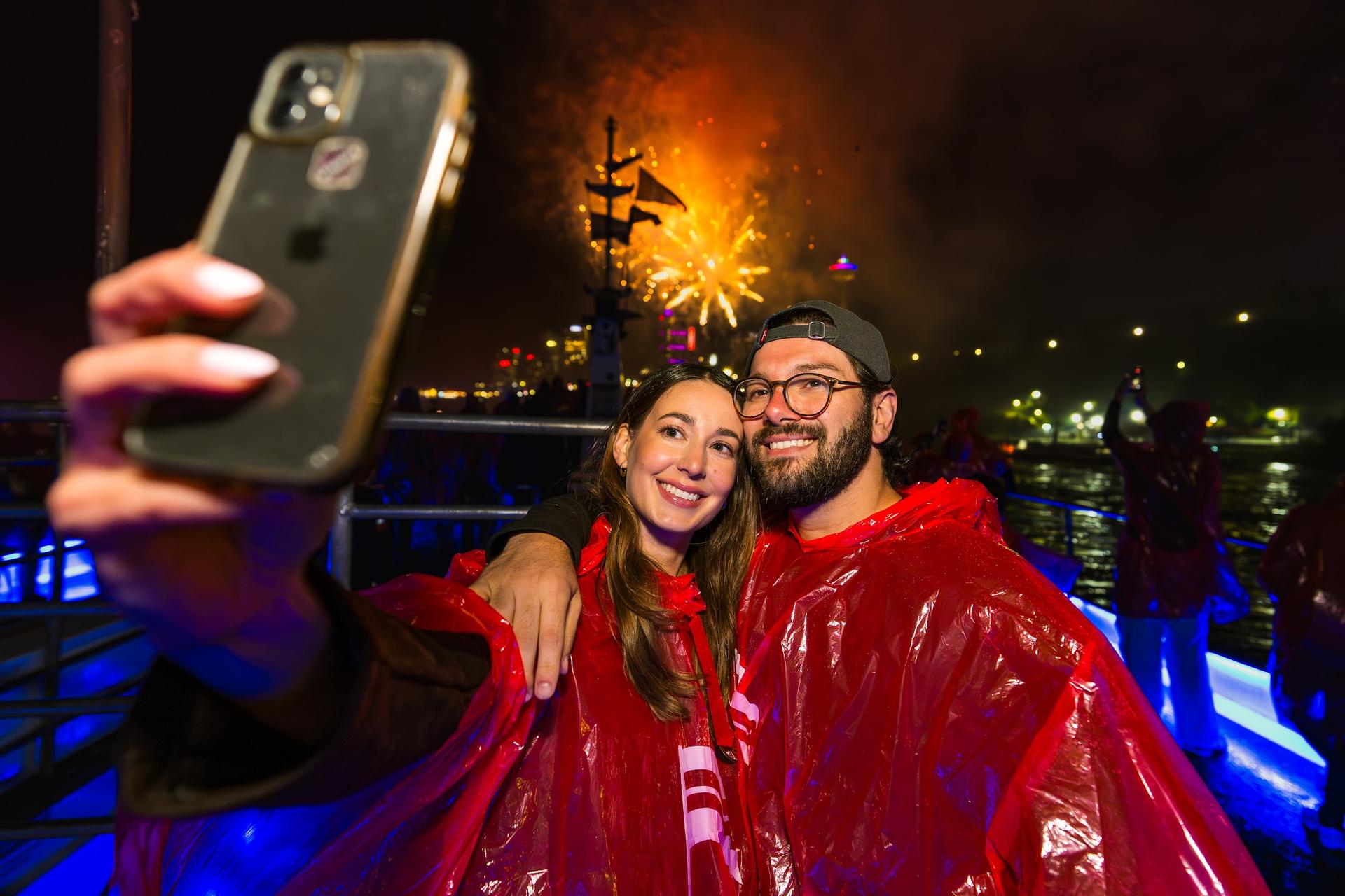 Guests take a selfie with fireworks over Niagara Falls